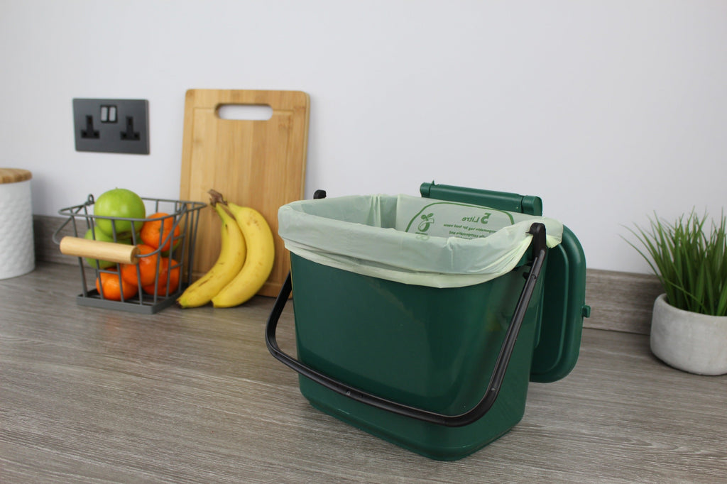 Small green food waste caddy lined with 5 litre compost liner, ideal for tidy and eco-friendly kitchen composting.