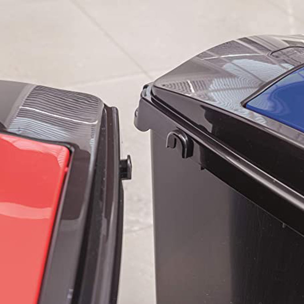 Close-up of two black recycling bins with red and blue lids, showing clip-on connectors designed to link bins together.