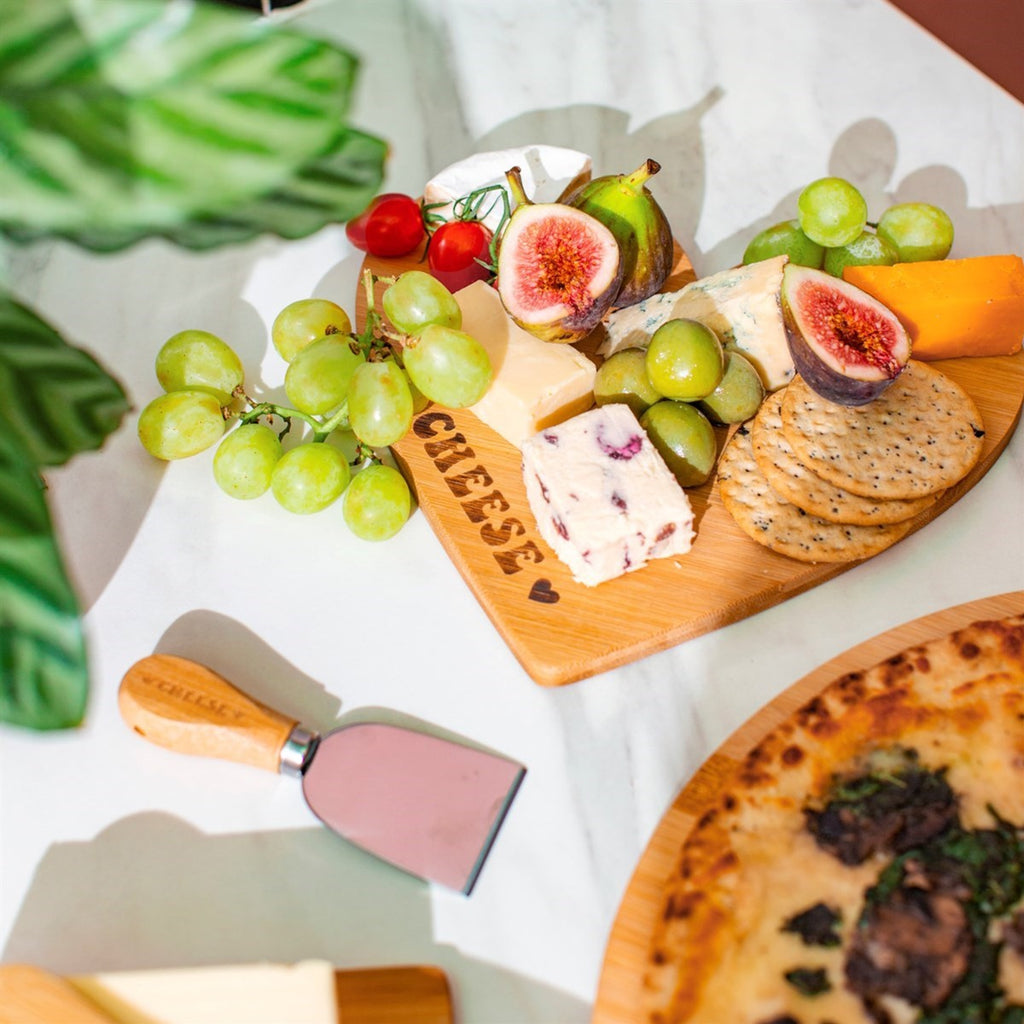 Heart Cheese board holding a variety of cheeses