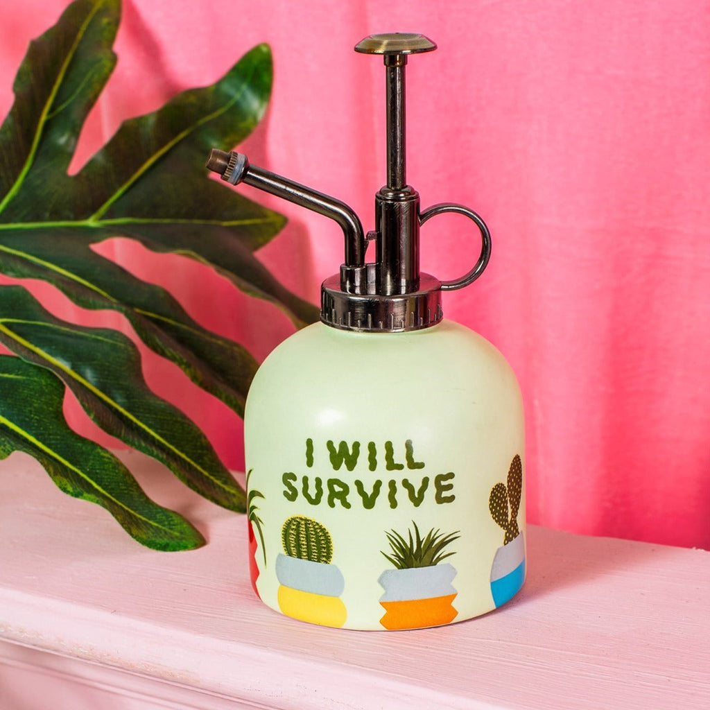 plant watering mister with bright pink background and plants
