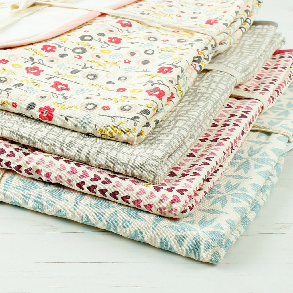 Variety of folded baby blankets in different colours and prints. Close up showing quality of fabric