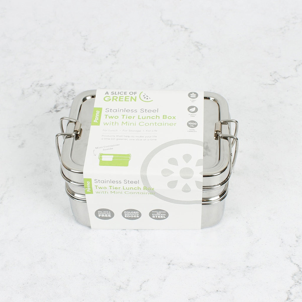 Stainless steel two-tier lunch box with mini container, shown wrapped in branded packaging, placed on a white marble background