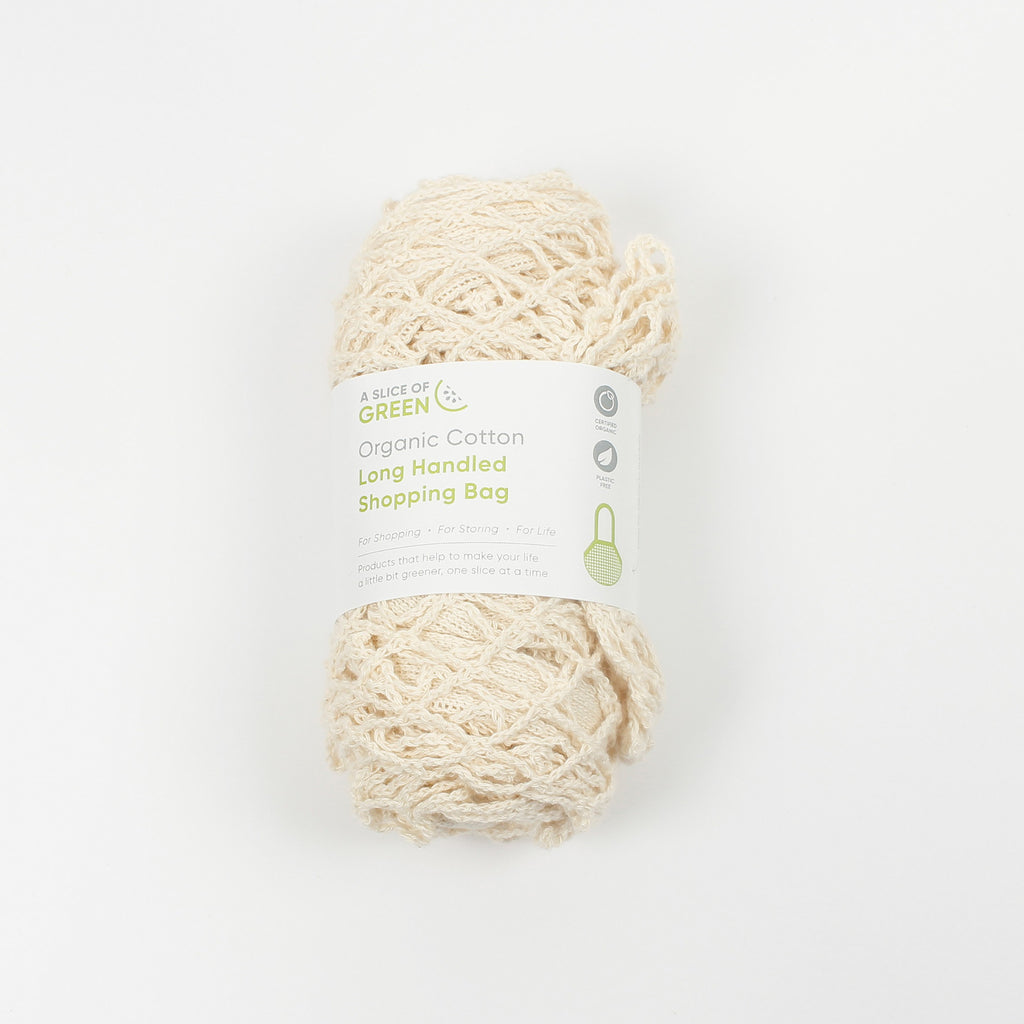 Rolled organic cotton mesh shopping bag with paper band labelled A Slice of Green, long handled and plastic-free
