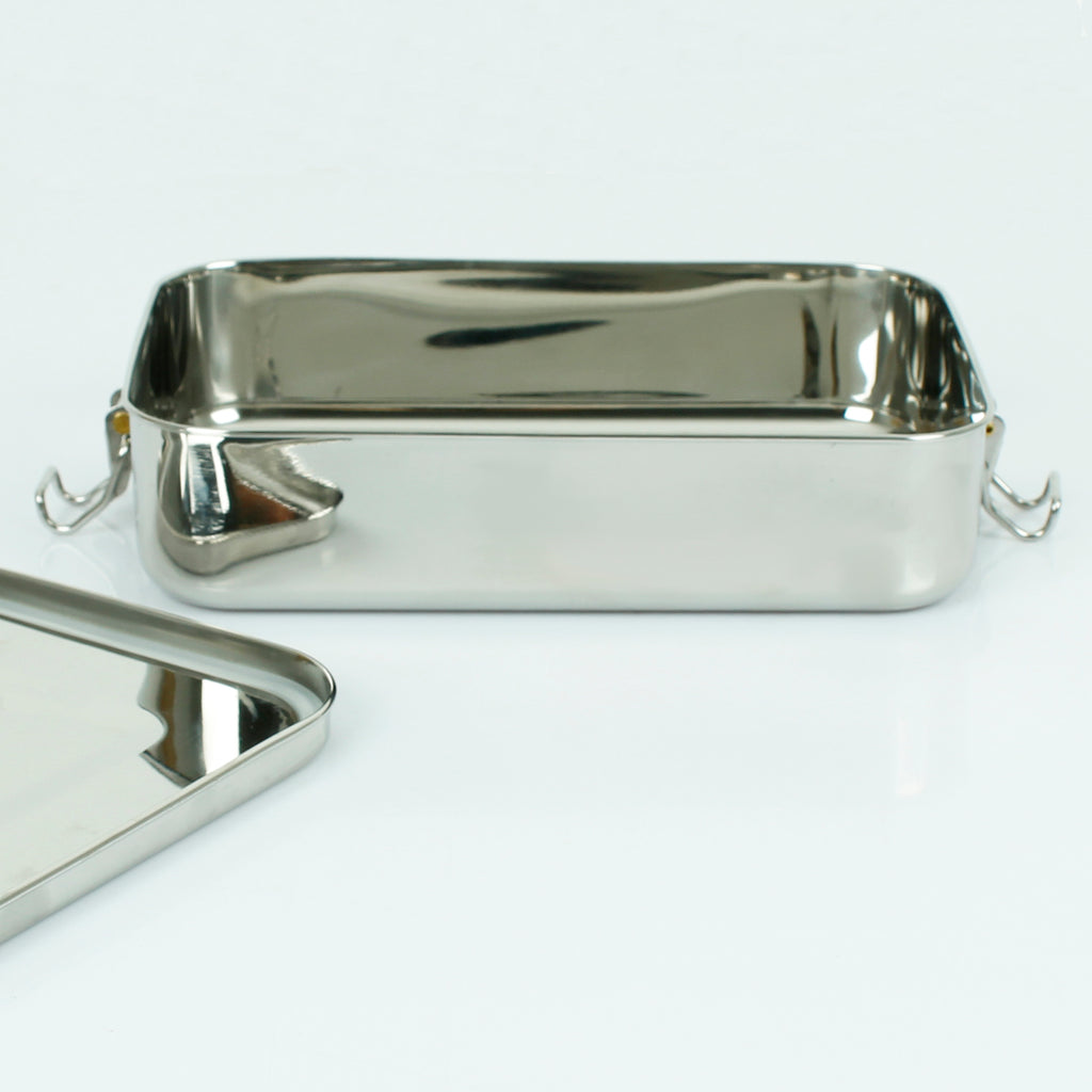 Stainless steel lunch box packed with fruit, crackers and a sandwich, lid off and placed beside the container